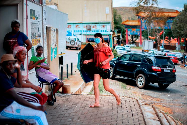 En kvinde med ansigtsmaske i Cyrildene - også kaldet Johannesburgs China Town. Afrika har foreløbig ikke meldt om en eneste smittet, men det tvivler mange på, ikke mindst fordi mange kinesere opholder sig på kontinentet.  Foto: Luca Sola/Ritzau Scanpix