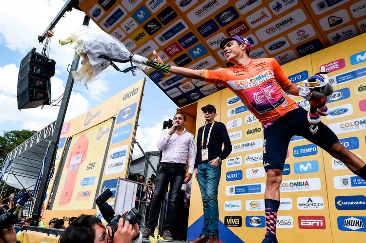 Det er ikke kun på cyklen, den 22-årige Sergio Higuita udfolder nærmest akrobatiske evner - også når sejrsblomsterne skal kastes ud til publikum ,sker det med stil.
' Foto: Juan Barreto/Ritzau Scanpix