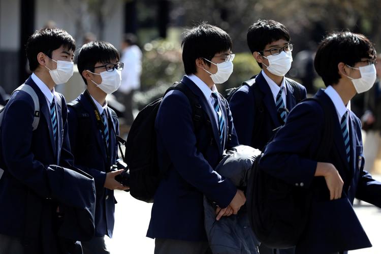 Skolebørn bærer maske under et besøg i templet Sensoji ved Tokyo. Japan vil begynde et forsøg med brug af hiv-medicin til patienter, der er smittet med coronavirus. Foto: Athit Perawongmetha/Ritzau Scanpix