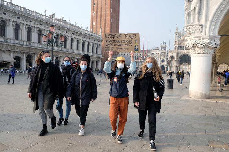 Det traditionsrige karneval i Venedig er aflyst efter over 200 italienere på kort tid er konstateret smittede med det nye coronavirus. På skiltet står 'Corona Tour: Vi har modet til ikke at være bange'. REUTERS/Manuel Silvestri   Foto: Manuel Silvestri/Ritzau Scanpix