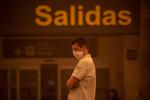 En mand venter udenfor Tenerifes South-Reina Sofia lufthavn under en sandstorm søndag den  23. februar. En italiensk turister på den spanske ø er smittet med coronavirus.  Foto: Desiree Martin/Ritzau Scanpix