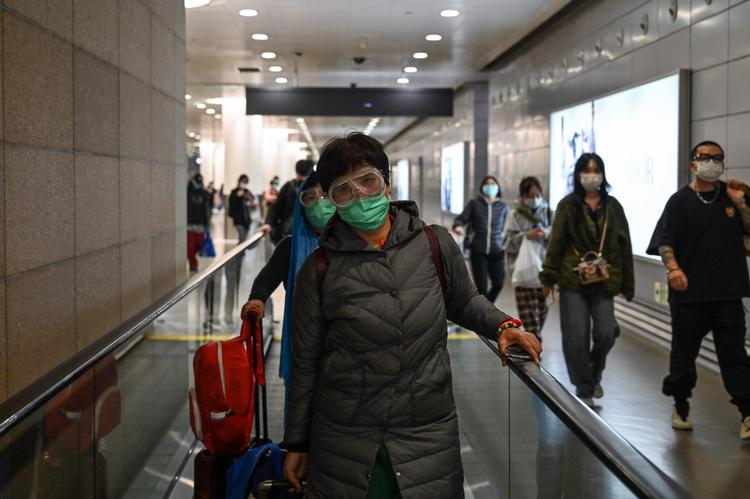 En passager i Pudong International Airport i Shanghai ankommer iført maske for at minimere risikoen for at blive smitte med corona-virus. Foto: Hector Retamal/Ritzau Scanpix