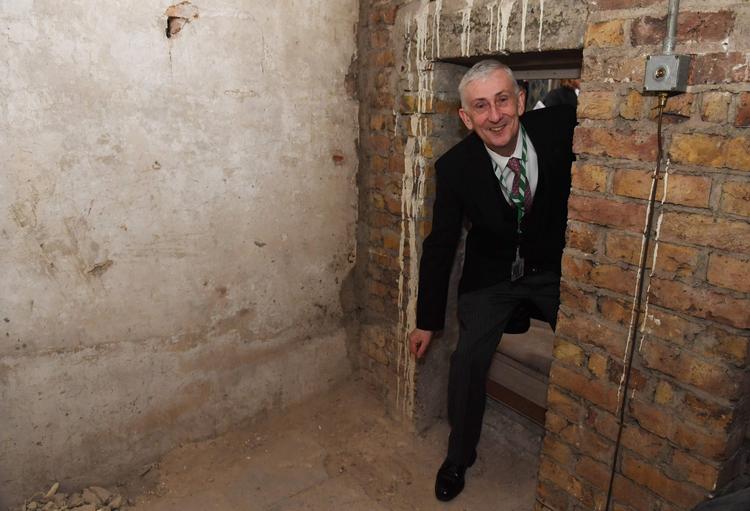 Speaker i the House of Commons i det britiske parlament, Lindsay Hoyle, kravler ind gennem en lille, overset dør i træpanelerne i Westminister, der viste sig at føre ind i et lille stenkammer, som gemte på en tilmuret døråbning fra 1660-61. Foto: Jessica Taylor/Ritzau Scanpix