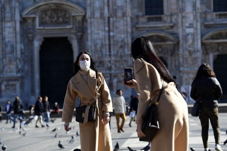 Kvinder med masker fotograferet i Milano i dag. Den smittede mand - en italiensk statsborger - rejste fra netop Milano via Istanbul til Nigeria.    Foto: Miguel Medina/Ritzau Scanpix