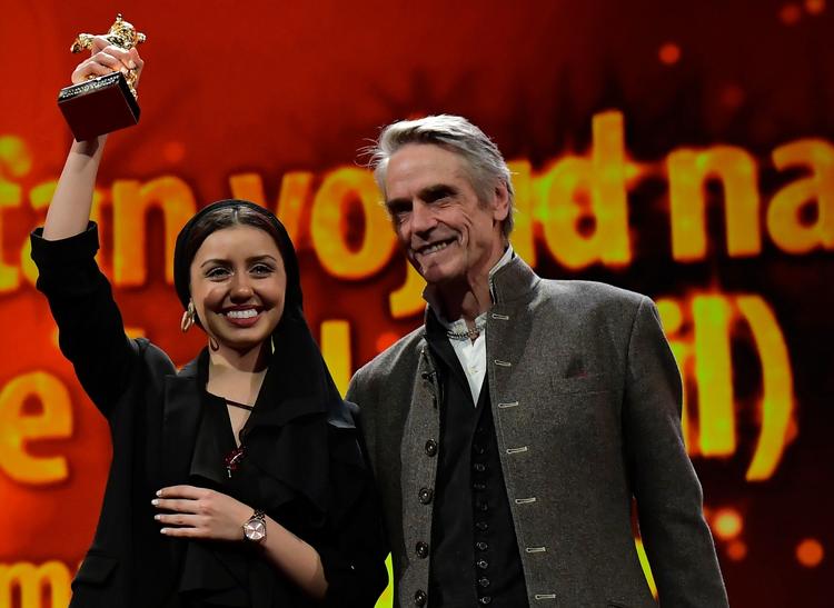 Instruktøren Mohammad Rasoulof kunne ikke deltage i prisuddelingen i Berlin, da han har udrejseforbud i Iran, derfor modtog hans datter, skuespillerinden Baran Rasoulof, prisen. Her ses hun med den britiske skuespiller, Jeremy Irons, der var en del af juryen.  Foto: Tobias Schwarz/Ritzau Scanpix