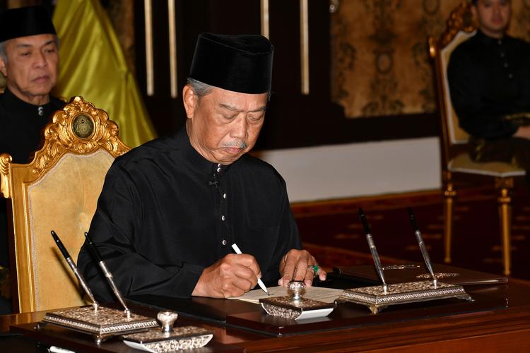 Muhyiddin Yassin underskriver et dokument under en ceremoni i Kuala Lumpur.S   Foto: Malaysia Information Department/Ritzau Scanpix