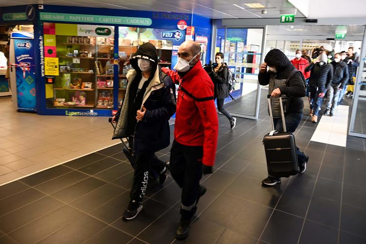 Mennesker med ansigtsmasker venter på en bus i Milano.  Foto: Jean-philippe Ksiazek/Ritzau Scanpix