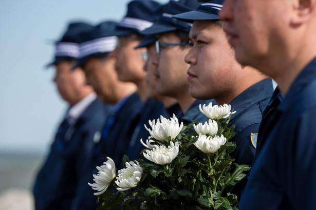 Betjente deltager i et minuts stilhed for ofrene. Foto: Athit Perawongmetha/Ritzau Scanpix
