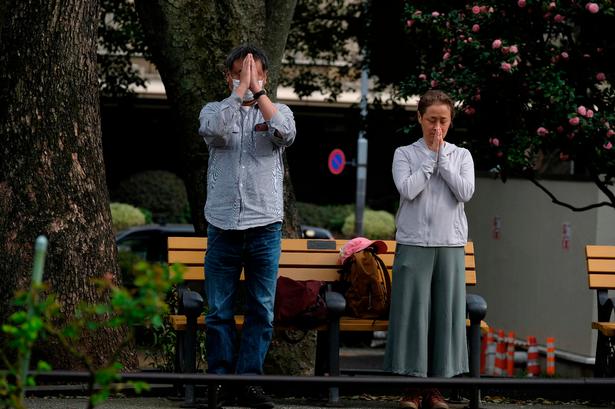 Sørgende beder for de døde ved et arrangement i en park i Tokyo. Foto: Kazuhiro Nogi/Ritzau Scanpix