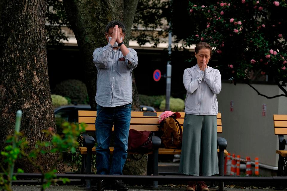 Sørgende beder for de døde ved et arrangement i en park i Tokyo. Foto: Kazuhiro Nogi/Ritzau Scanpix