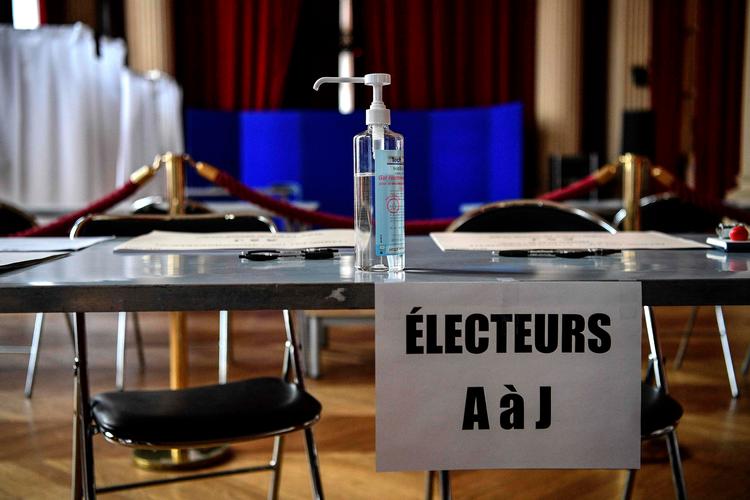     Flasken med håndsprit er allerede klar på bordet i et valglokale i Paris. Vælgerne skal overholde nye instrukser for at undgå smitte under valghandlingen. Men mange frygter for forløbet af 2. omgang af valget om en uge i de fleste større byer. Foto: Christophe Archambault/Ritzau Scanpix