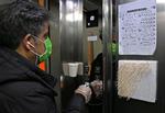 Iraner bruger en pind til at trykke på knappen i en elevator i en offentlig bygning. Den islamisske republik kæmper med et omfattende udbrud af covid-19.
  Foto: Atta Kenare/Ritzau Scanpix