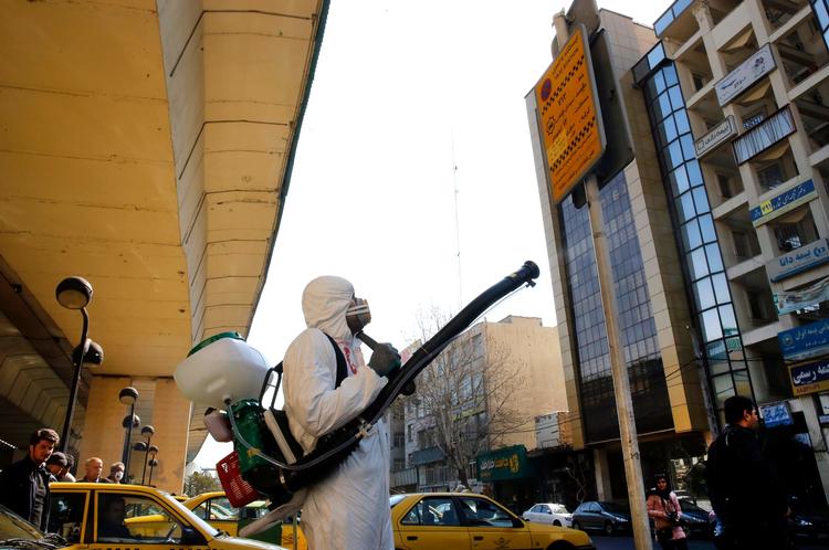 Iransk brandmand desinficerer en gade i hovedstaden Teheran..
  Foto: Str/Ritzau Scanpix