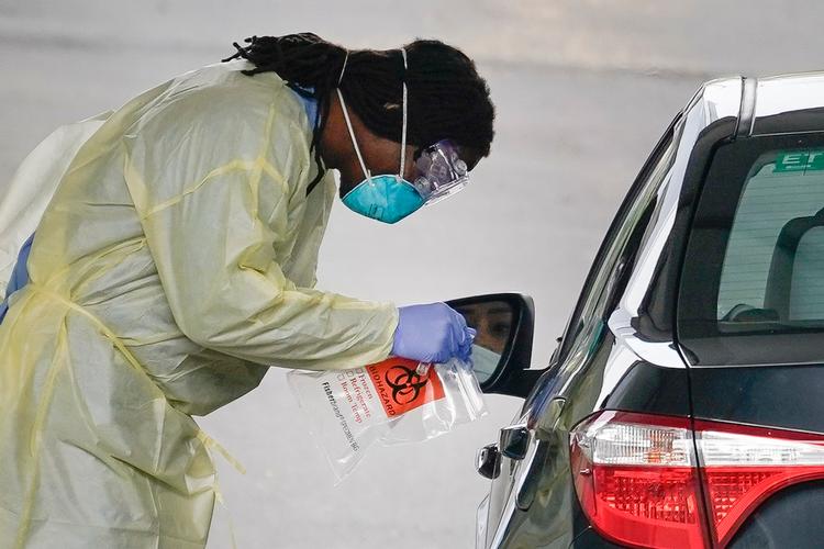    Rundt om i USA skriger man på flere sæt, så de kan teste folk med symptomer. I Arlington, Virginia, havde denne sundhedsarbejder dog udstyret i orden, så han på denne drive through test-station kunne tjekke, om bilisterne var smittet.  Foto: Drew Angerer/Ritzau Scanpix