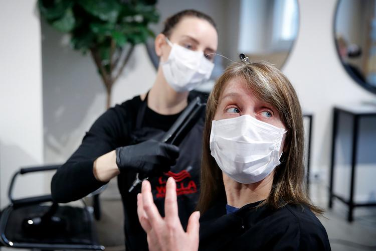 Vi lytter til myndighedernes råd og snakker os selv frem til de praktiske løsninger. Hos frisør Camilla Rathmann i Frederiksberg Centret havde kunden taget ansigtsmaske med til dem begge.    Foto: Jens Dresling/POLFOTO