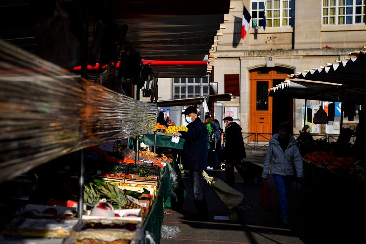   De populære udendørs markeder med tæt nærkontakt risikerer at blive de næste ofre for regeringens stramninger - til gengæld overvejer den at tillade boghandlere at åbne. . Foto: Christophe Archambault/Ritzau Scanpix