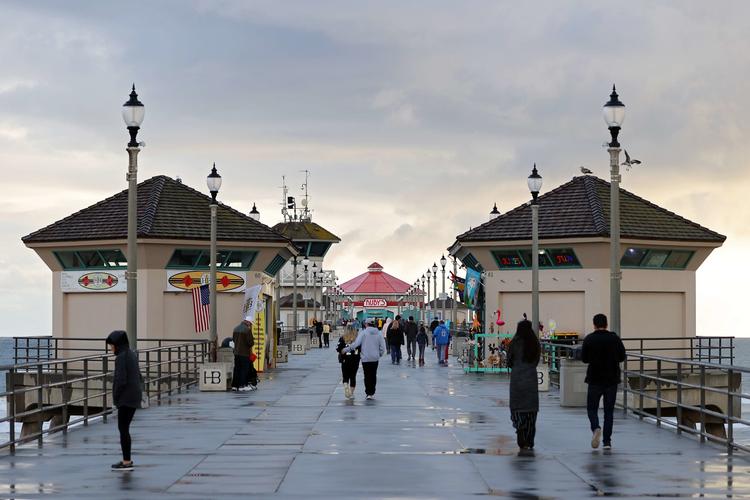 Folk går på Huntington Beach Pier i Californien. Men det er slut med den slags fornøjelser for en periode. Californien har pålagt sine indbyggere at blive hjemme på grund af coronavirus.   Foto: Michael Heiman/Ritzau Scanpix