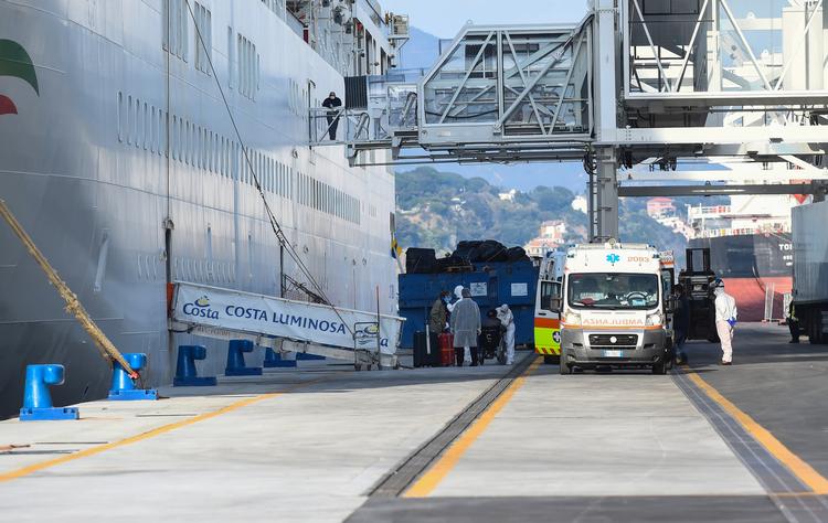 Passagerer om bord på Costa Luminosa ledes fra skibet og om bord på en ambulance i Savona, nær Genoa i Italien. Men mange må væbne sig med tålmodighed og blive på skibet noget tid endnu, herunder et dansk ægtepar.  Foto: Massimo Pinca/Ritzau Scanpix