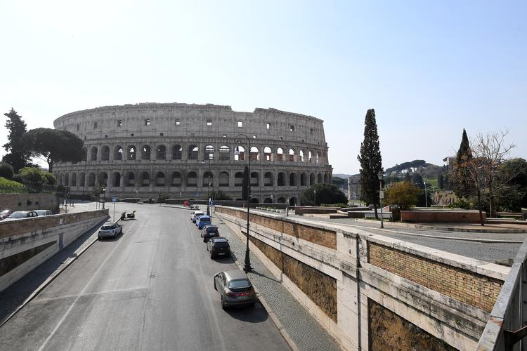Italienerne holder sig inden døre for at begrænse smitte, og i dag begynder landet fabrikker at lukke ned for produktion. Her er området foran den antikke skueplads Colosseum i Rom, som normalt summer af liv. Foto: Alberto Lingria/Ritzau Scanpix