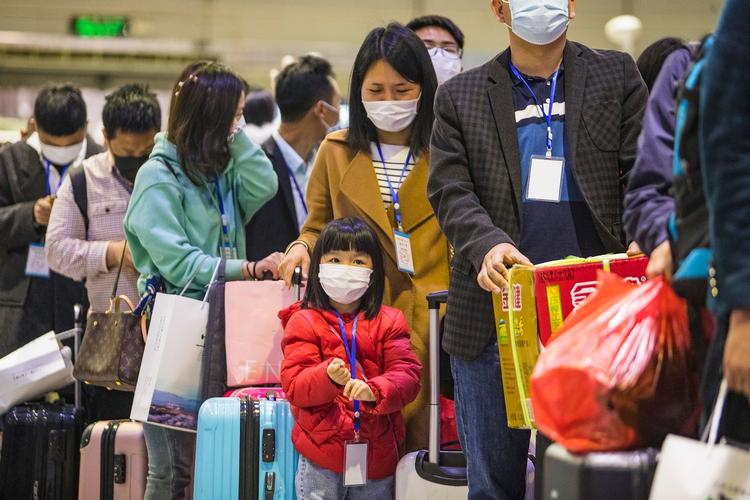 Migrantarbejdere og deres familier venter på et tog, der skal tage dem tilbage til Kinas Hubei-provins som så småt er blevet åbnet igen.
  Foto: Str/Ritzau Scanpix