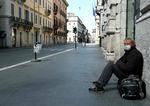 En hjemløs sidder på gaden Via del Corso i det centrale Rom. Landet har indført straf på op til fem års fængsel kan være konsekvensen i Italien, hvis man bryder karantæneregler efter virussmitte.   Foto: Vincenzo Pinto/Ritzau Scanpix