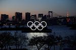 De gigantiske olympiske ringe lyser fortsat over Odaiba Marine Park i Tokyo, men legene bliver først afholdt i sommeren 2021. Foto: Issei Kato/Ritzau Scanpix