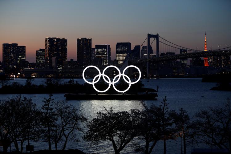De gigantiske olympiske ringe lyser fortsat over Odaiba Marine Park i Tokyo, men legene bliver først afholdt i sommeren 2021. Foto: Issei Kato/Ritzau Scanpix