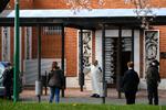 En præst afsiger en bøn på afstand foran familiemedlemmer til en coronapatient, der er død ved kirkegården La Almudena cemetery i Madrid. Spanien er lige nu et af de værst ramte lande i verden af coronasmitten.   Foto: Oscar del Pozo/Ritzau Scanpix