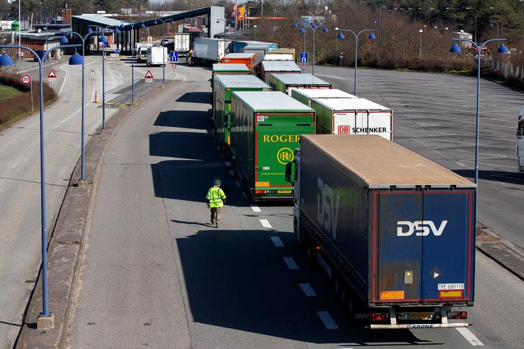 Det har store økonomiske konsekvenser for samfundet, at daginstitutioner og uddannelsesinstitutioner er lukket ned, forsamlinger over 10 personer forbudt og grænsen lukket for udlændinge uden anerkendelsesværdige formål i Danmark. Her er det Rødby Færgehavn, hvor lastbiler holder i kø ved grænsekontrollen. Foto: Finn Frandsen/POLFOTO