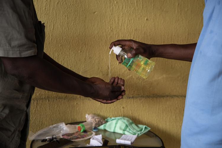En sikkerhedsvagt deler håndsprit ud ved indgangen til et supermarked for at forhindre spredning af coronavirussen i hovedstaden Ouagadougou i Burkina Faso. Burkina Faso er et af de afrikanske lande som har bekræftede smittede med coronavirus. Foto: Olympia De Maismont/Ritzau Scanpix
