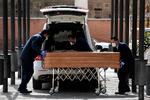 Bedemænd bærer masker, mens de bærer en kiste i Madrid. Spanien er en af de lande, der aktuelt er hårdest ramt af COVID-19. 4.000 er dødstallet oppe på.  Foto: Oscar del Pozo/Ritzau Scanpix