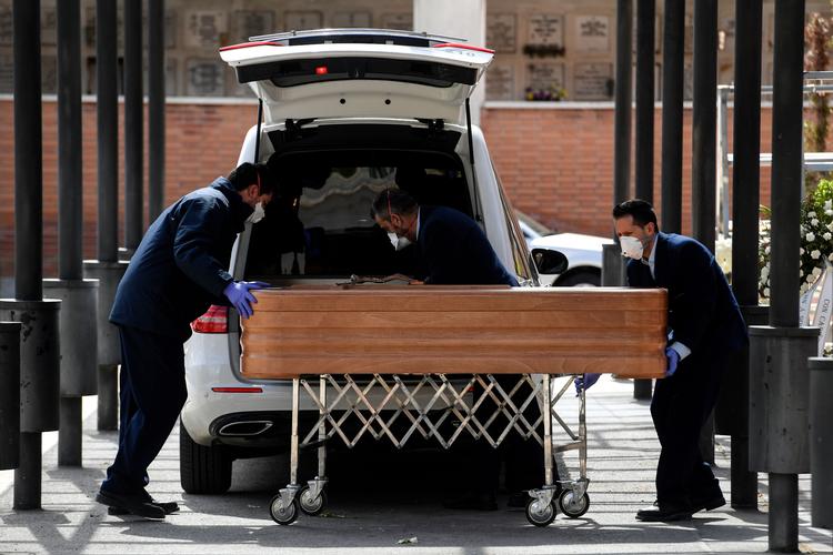 Bedemænd bærer masker, mens de bærer en kiste i Madrid. Spanien er en af de lande, der aktuelt er hårdest ramt af COVID-19. 4.000 er dødstallet oppe på.  Foto: Oscar del Pozo/Ritzau Scanpix
