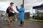 En cyklist får taget sin temperatur i et drive-in testcenter i New Orleans. I USA er der nu over 100.000 mennesker, som er bekræftet smittet med coronavirussen. Foto: Kathleen Flynn/Ritzau Scanpix