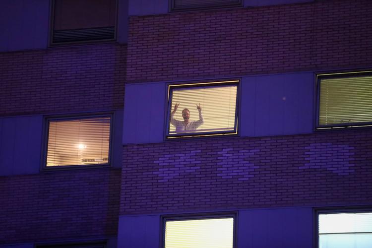 En patient på Gregorio Maranon-hospitalet i Madrid vinker fra sit vindue fredag.  Foto: Sergio Perez/Ritzau Scanpix