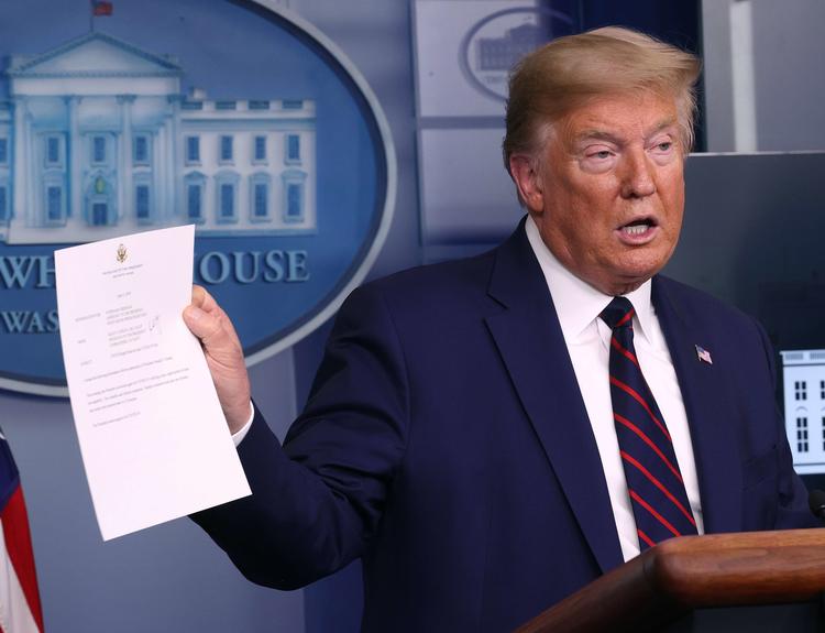 Trump fotograferet i går, hvor han viser resultatet af en ny test, som viser, at han ikke er smittet med corona.  Foto: Win Mcnamee/Ritzau Scanpix