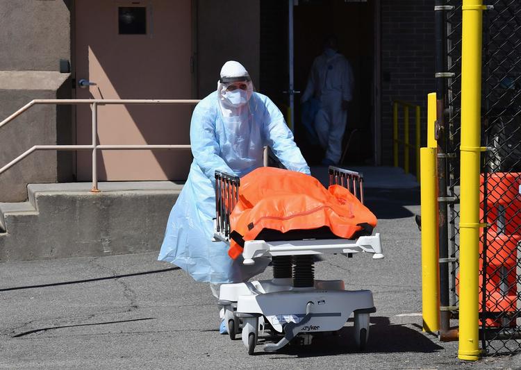 De fleste coronarelaterede dødsfald i USA rammer millionbyen New York. Her flytter en portør en afdød coronapatient på et hospital i bydelen Brooklyn torsdag 2. april til en kølevogn, der bliver brugt som midlertidigt opbevaringssted for ligene.  Foto: Angela Weiss/Ritzau Scanpix