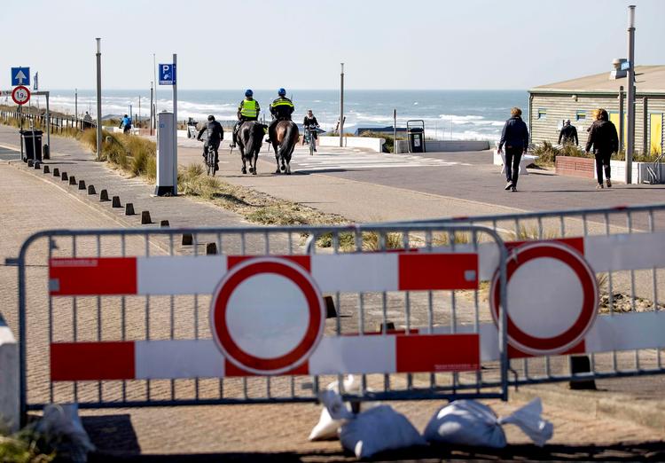 Politifolk til hest patruljerer et strandområde i hollandske Zandvoort. Foto: Koen Van Weel/Ritzau Scanpix