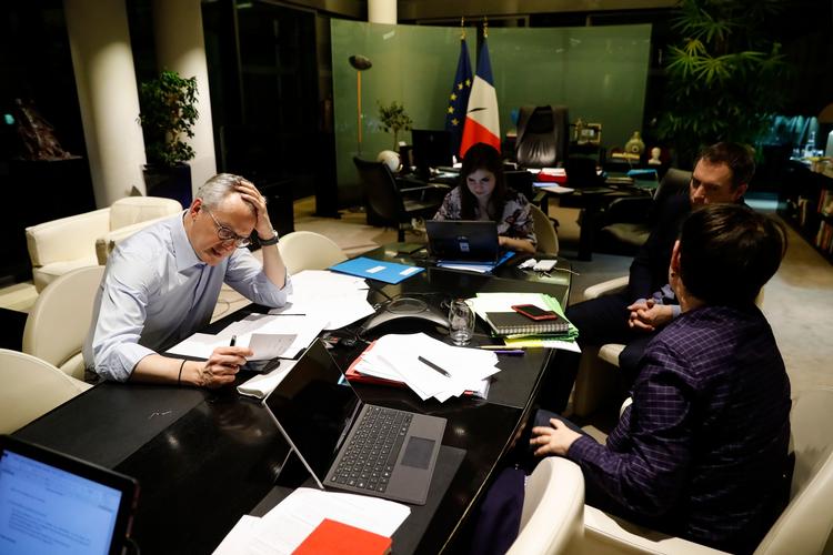 Den franske finansminister Bruno Le Maire (tv) taler i telefon med sin tyske kollega, mens hans rådgivere arbejder er optaget af at finde svar på de udfordringer, som coronakrisen har kastet den franske og europæiske økonomi ud i. Foto: Thomas Samson/Ritzau Scanpix