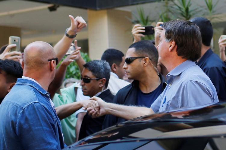 Brasiliens præsident, Jair Bolsonaro, trodser fortsat de sundhedsfaglige anbefalinger, som resten af verden følger, om for eksempel at holde afstand. Her giver han hånd til en tilhænger i hovedstaden Brasília. Foto: Adriano Machado/Ritzau Scanpix