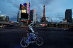 En mand på cykel står på Las Vegas strip. De amerikanske  corona-restriktionløber frem til 30. april. Nu overvejer Trump, hvornår de skal hæves. Foto: Shannon Stapleton/Ritzau Scanpix