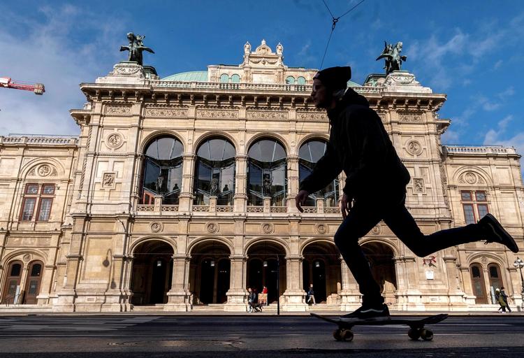 En mand på skateboard passerer den lukkede statsopera i Wien. Landet begynder oplukningen mandag.  Foto: Joe Klamar/Ritzau Scanpix