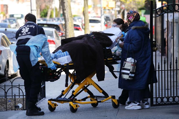 En patient bliver transporteret ind i en ambulance i New York, der er det hårdst ramte område i USA.  Foto: Spencer Platt/Ritzau Scanpix