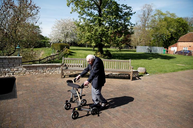 Den tidligere kaptajn Moore, der bevæger sig rundt med rollator efter et hoftebrud, har sat sig som mål at gå 25 meter rundt i sin have 100 gange inden sin 100-års fødselsdag 30. april. Foto: Peter Cziborra/Ritzau Scanpix