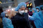 En sygeplejerske bliver rørt og tører en tåre væk foran et hospital i New York, da betjente holder kommer for at hylde dem.  Foto: Mike Segar/Ritzau Scanpix
