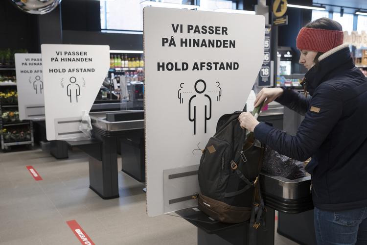 Kunder og personale i supermarkedet Netto, H.C Ørstedsvej 25, Frederiksberg. Plancher og klistermærker informerer om at holde afstand og undgå smitte.  Foto: Mikkel Hørlyck/POLFOTO