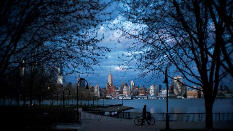 En mand trækker sin cykel igennem en tom park i New York. Antallet af døde som følge af coronavirus er faldet det seneste døgn.  Foto: Eduardo Munoz/Ritzau Scanpix