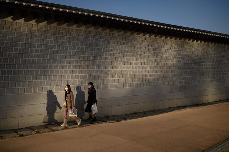Folk på gaden i Seoul bærer maske. Sydkoreanske myndigheder melder søndag om 16 nye tilfælde af raskmeldte, der igen er smittet med coronavirus. Foto: Ed Jones/Ritzau Scanpix