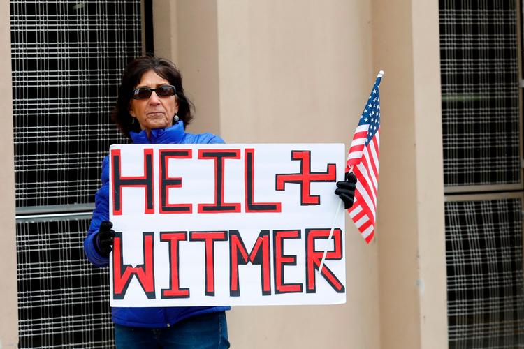 En demonstrant i Michigan retter sin vrede mod delstatens guvernør Gretchen Whitmer, der har beordret en nedlukning af staten. Foto: Jeff Kowalsky/Ritzau Scanpix