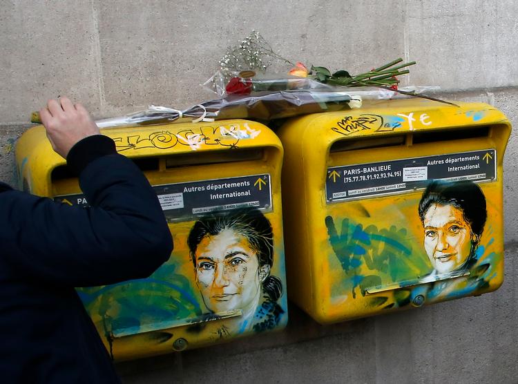 Christian Guémy har portrætteret politiker og Holocaust-overlever Simone Veil. Da portrættet i 2019 blev overmalet med hagekors, rykked ehan selv ud for at rette op på skaderne. Hans sidste værk inden udgangsforbuddet var et kærestepar, der kysser med mundbind.  Foto: Michel Euler/Ritzau Scanpix