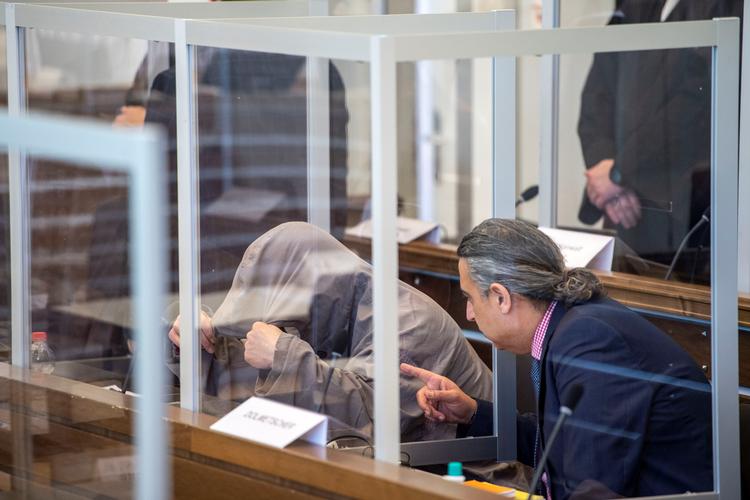 Coronaepidemien sætter sit præg på retssagen i den tyske by Koblenz mod syrerne Anwar Raslan og Eyad al-Gharib, der er anklaget for statsterror. De anklagede, anklagere og forsvarere befinder sig bag plexiglas. 76 akkrediterede journalister fra hele verden skal deles om 14 siddepladser. Foto: Pool/Ritzau Scanpix
